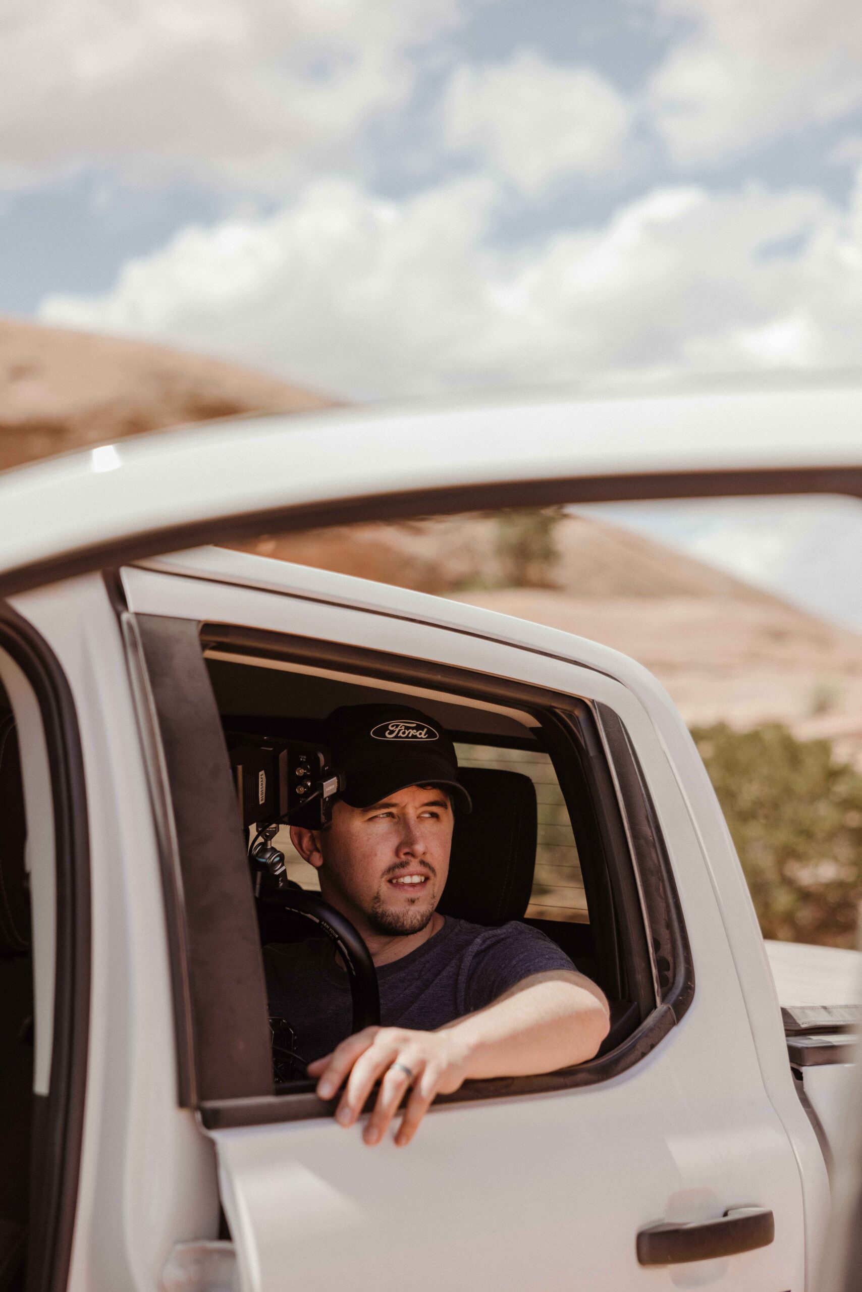 Chris-Bacarella-Moab-People-25_11 Phillip in passenger seat of a white pickup truck at Moab in the desert